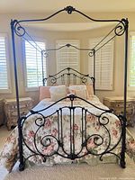 Full view of assembled queen canopy bed frame showing headboard, footboard, posts and canopy rails
