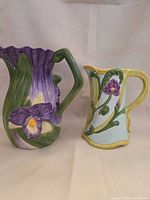 Front view of both ceramic pitchers showing floral designs