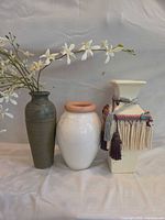 Front view of three vases with flower spray