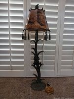 Full view of bronze frog motif floor lamp with shade and cord