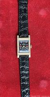 Front view of entire watch on red background showing case, dial and strap