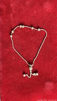 Full view of sterling silver bolo bracelet on red background