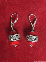 Full view of both earrings on red background