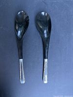 Two utensils side by side showing sterling handles and black heads