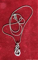 Full view of necklace and pendant on red background