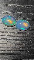 Pair of oval cabochon opals showing multicolour play-of-colour