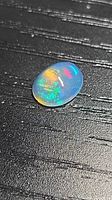 Oval crystal opal cabochon showing multicolored play-of-color