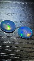 Both oval cabochon opals showing body color and play-of-color