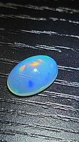 Top view of oval cabochon opal showing play-of-colour