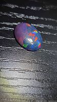 Top view of opal showing multicolor flashes on dark base