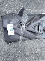 Folded black grill cover with clear tape and hook-and-loop strap