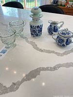 Group shot showing all five pieces: pressed glass creamer and sugar, Gryphonware porcelain creamer and sugar with lid, opaline apothecary bottle with stopper