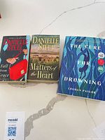 Front covers of all three novels displayed on countertop