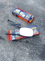 Mirror with packaging and hardware on asphalt