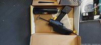 Open box showing Wagner Pow-R Caulk gun, battery cylinder, manual