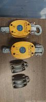 Front of two wooden snatch blocks and two steel pulleys