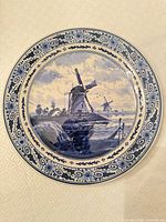 Front of Delft plate showing windmill scene and floral border