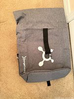 Front view showing Orangetheory logo, roll-top strap, exterior zip pocket