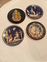 Front view of all four plates showing artwork and gilding
