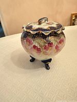 Overall view of porcelain trinket box with lid and tripod feet