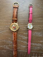 Both wristwatches side by side showing full view of straps and dials