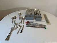 overview of all flatware, skewers, grater and trays on table