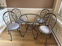 Full view of table and four chairs showing design and upholstery