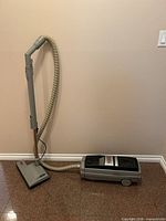 Full view of canister vacuum with hose, wand and nozzle