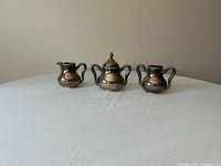 Front view of three-piece silver-plated set showing overall form and size comparison