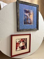 Both framed needlepoint artworks side by side