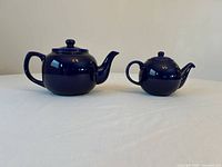 Front view of both cobalt blue teapots showing relative sizes and shape