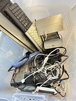 Bin with keyboards, external drive, phone, cables