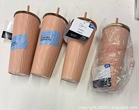 Four peach/blush tumblers, three with tags, one wrapped