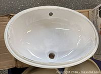 top view of white oval porcelain sink showing faucet and drain openings