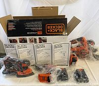 Box contents laid out: drill, circular saw, sander, flashlight, batteries, charger, manuals