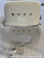Front of white Smeg toaster on top of original box