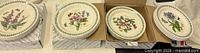 Three open boxes showing stacks of Portmeirion Botanic Garden plates