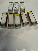 Eight packaged white decorator electrical devices – six rocker switches and two duplex outlets