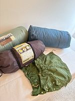Tent bag, sleeping pad bag, sleeping bag sack and gaiters on table