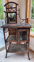 Full view of etagere showing faux bamboo frame, mirror, shelves, glass door cabinet