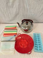 Group shot of kettle, splatter lid, silicone bags with sliders, ice tray