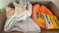 Box containing white rags, two Victor mouse-trap packs, orange microfiber mitt