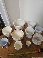 Group shot of all planters and saucers on table showing variety of sizes and patterns