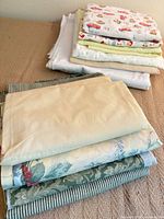 Two stacks of folded cotton and flannel fabrics on bed