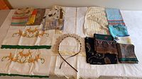 Full lot laid out showing scarves, table linens and crocheted pieces