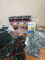 Lot overview showing sealed Philips light boxes, loose strands, star topper, clips and reel