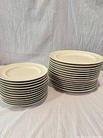 Two stacks of off-white plates in two sizes