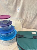 Stacked glass bowls with lids, carrier bag, bagged plastic containers