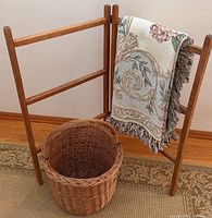 Wooden ladder, wicker basket, throw draped over ladder