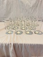 Front view of all 12 clear glass tumblers standing on table